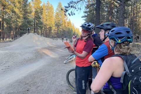 A mountain bike coach reviews video footage with her clients during a Cog Wild lesson. 